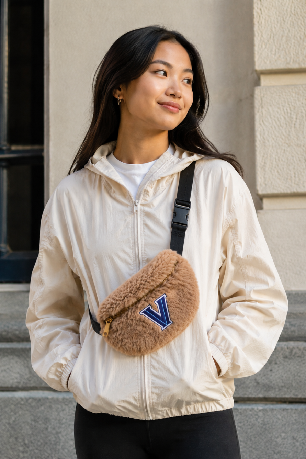 Beige faux fur sling bum bag on black strap, blue 'V' front patch with zipper