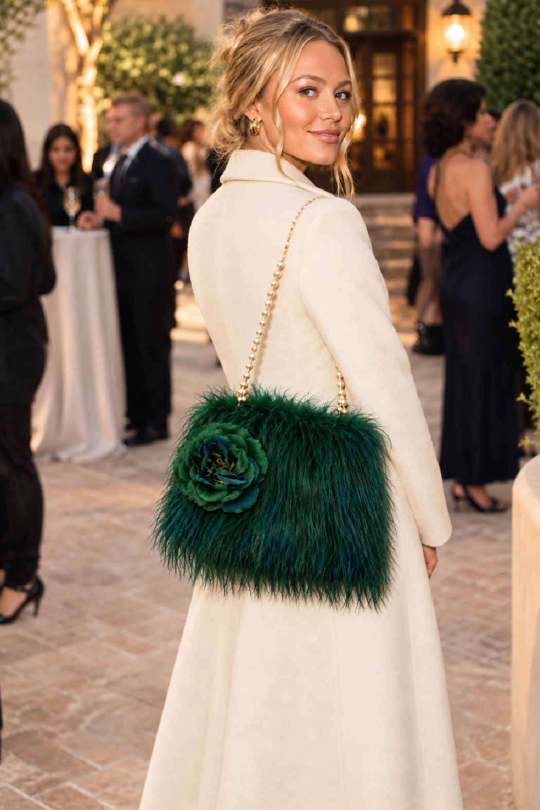 Dark green faux fur shoulder bag with flower applique and fringe trim.