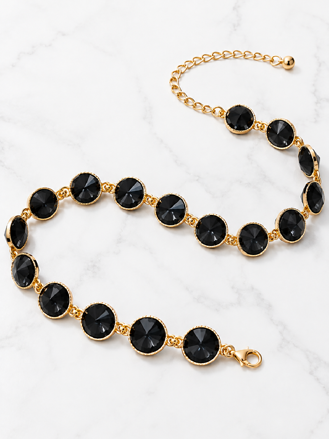Black crystal belt with round stones, gold-tone links and lobster clasp, laid flat