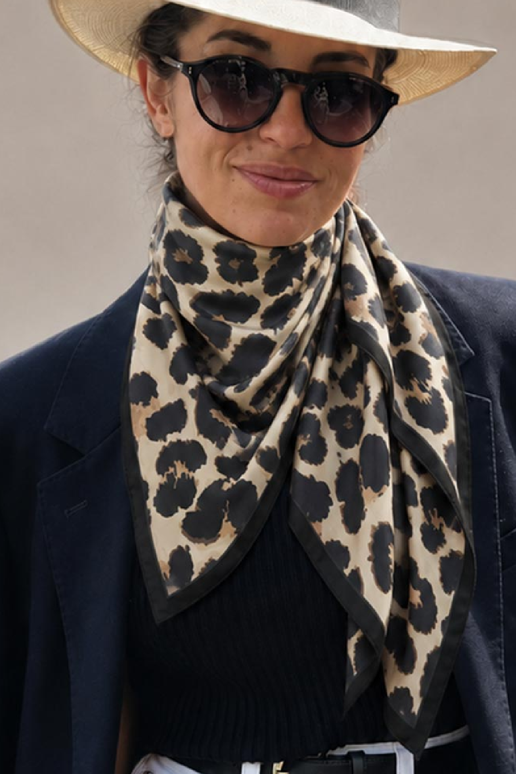 Leopard-print scarf with charcoal spots and black border, draped around the neck