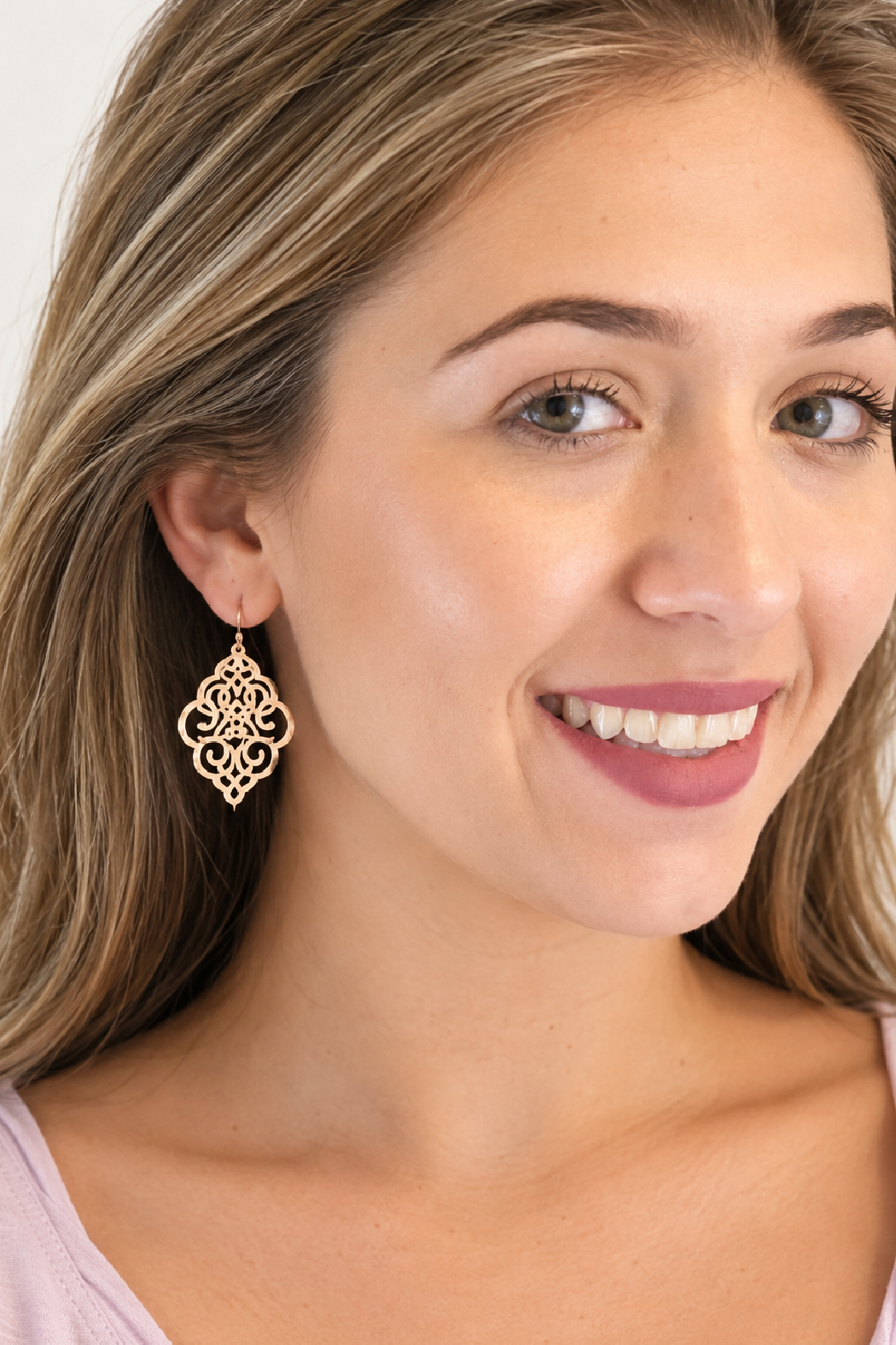 Gold-tone filigree scroll drop earrings with circular cutout design